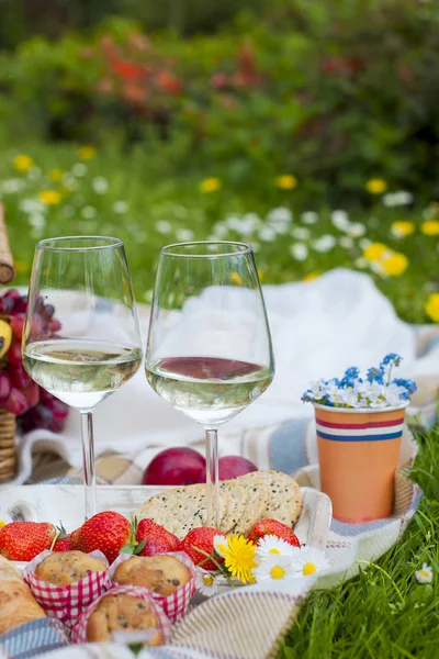 Due bicchieri di vino e fragole. Picnic in una radura con fiori. Primavera in Olanda. Posto per il testo. vacanze . — Foto Stock