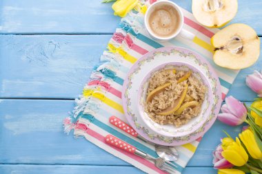 bir fincan hoş kokulu kahve ve bir ayva ile yulaf lapası. Sağlıklı ve lezzetli bir kahvaltı. Bahar lale mavi ahşap arka plan üzerinde. Metin için ücretsiz yöntemi.