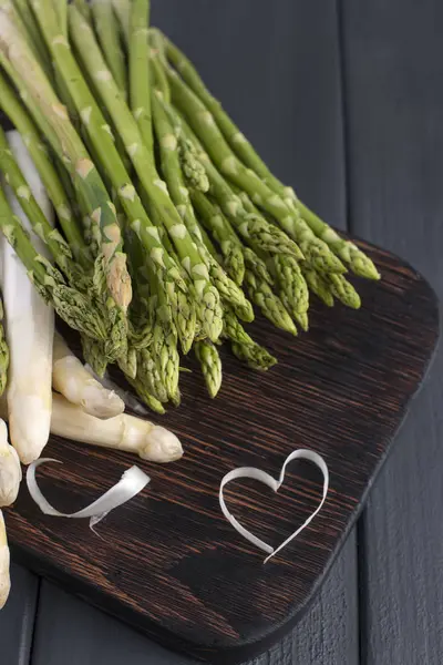 Weißen Spargel und grünen, auf einem Holzbrett auf dem Tisch. Sommergemüse. Gesunde Ernährung. Vegetarier. Freiraum für Text. Kopierraum — Stockfoto