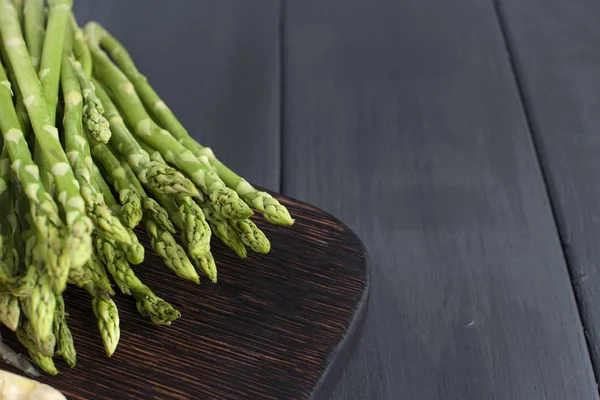 Green asparagus, on a wooden board on a table. Summer vegetables. Healthy food. A vegetarian. Free space for text. Copy sapce — Stock Photo, Image
