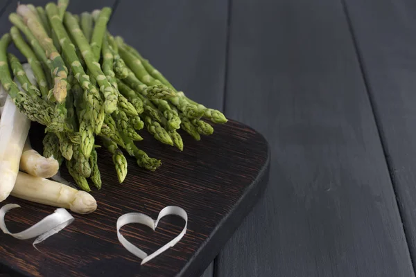 Weißen Spargel und grünen, auf einem Holzbrett auf dem Tisch. Sommergemüse. Gesunde Ernährung. Vegetarier. Freiraum für Text. Kopierraum — Stockfoto