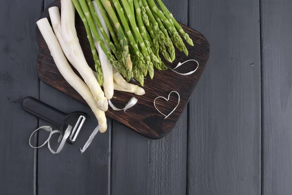 Weißen Spargel und grünen, auf einem Holzbrett auf dem Tisch. Sommergemüse. Gesunde Ernährung. Freiraum für Text. Kopierraum. flache Lage — Stockfoto