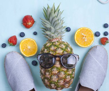 Ananas ve tatlı çilek, Ayakkabı ve mavi bir arka plan üzerinde güneş gözlüğü. Metin için özgür yer. Alanı, düz yatıyordu kopyalama