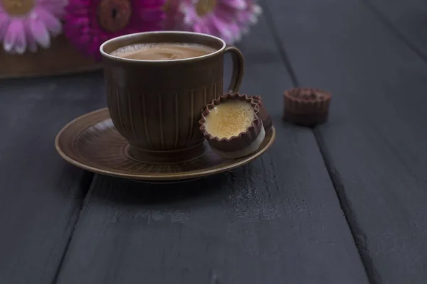 Delicioso chocolate com leite, um buquê de flores frescas e um café aromático matinal. Fundo de madeira preto, espaço livre para texto. Espaço de cópia — Fotografia de Stock