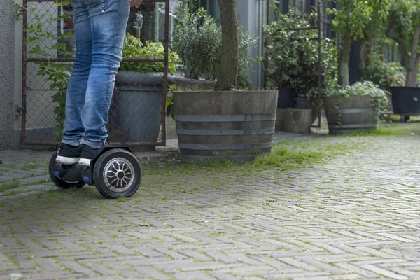 Tecnología moderna, un hombre está montando en una pizarra. Primer plano de Dual Wheel Self Balancing Electric Skateboard Smart. en scooter eléctrico al aire libre. Copiar espacio —  Fotos de Stock