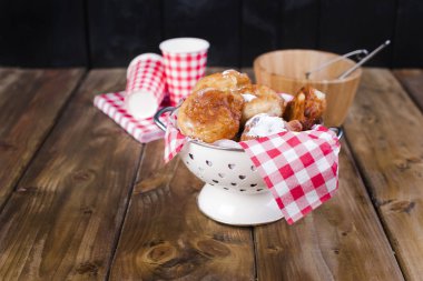 Ev yapımı kızarmış topları ile pudra şekeri. Peçete kırmızı kafes ve cam. Kahverengi ahşap arka plan. Geleneksel tatlı kek Hollanda. Metin için yer,