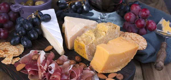Farklı peynir, jambon ve üzüm. Aperatif şarap için. Afiş.
