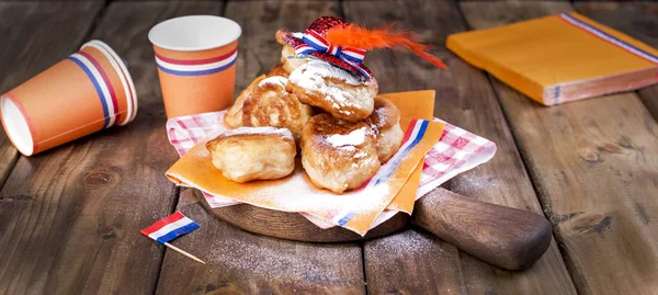 Traditionele Nederlandse zoete gebakjes. Feestdag van de koning. Decor. Oranje dingen voor de vakantie. Nederland. Papier gebruiksvoorwerpen voor een picknick en een vakantie. — Stockfoto