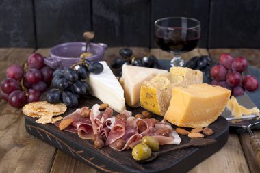 Farklı Hollanda peynir. Jambon, üzüm, zeytin ve aperatifler. Metin için özgür yer. kopya alanı