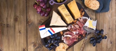 Farklı Hollanda peynir. Jambon, üzüm, zeytin ve aperatifler. Metin için özgür yer. kopya alanı. düz yatıyordu. afiş