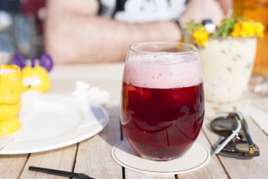 Cafe ve güneş ışığı. Bir bardak Belçika meyve bira. Alkol masada.