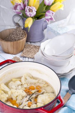 Karnabahar kırmızı bir dökme demir pişmiş. Mavi havlu. Metin için özgür yer. Aile yemeği. Diyet gıda.