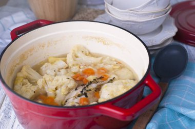 Karnabahar kırmızı bir dökme demir pişmiş. Mavi havlu. Metin için özgür yer. Aile yemeği. Sebze. Hazır yemek.