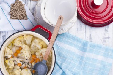 Karnabahar kırmızı bir dökme demir pişmiş. Mavi havlu. Metin için boş alan.