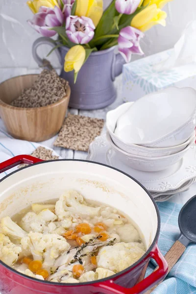 Karnabahar kırmızı bir dökme demir pişmiş. Mavi havlu. Metin için özgür yer. Aile yemeği. Diyet gıda.