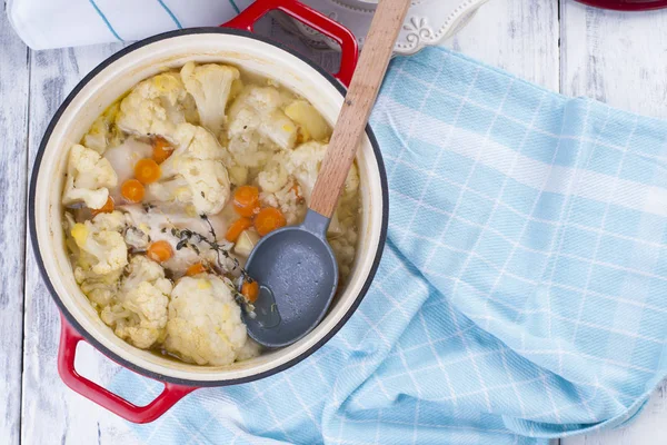 Karnabahar kırmızı bir dökme demir pişmiş. Mavi havlu. Metin için boş alan