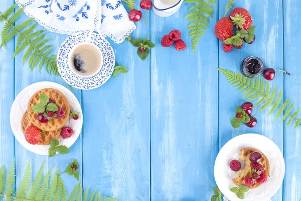 Delicioso desayuno de verano, pasteles caseros y café perfumado. Sobre un fondo de madera azul, bayas y hojas verdes. Copiar sapce, plano laico —  Fotos de Stock