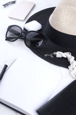 Bayan aksesuarlar, Not defteri girişleri, telefon ve pasaport için. Şapka ve güneş gözlüğü. Tatil. Beyaz arka plan. Uzay kopyalayın. düz lay.