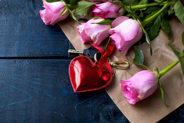 Un bouquet de roses et de biscuits comme cadeau pour une journée d'amoureux sur un fond noir et un cœur rouge . — Photo