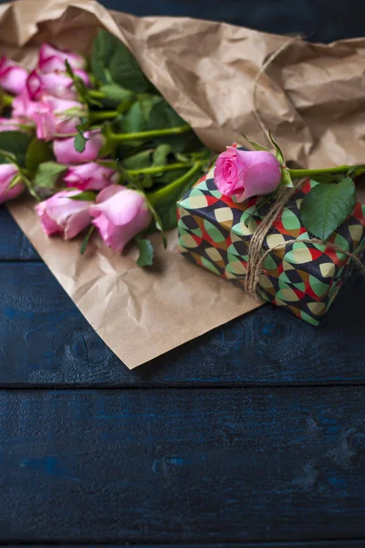 Un bouquet de roses roses, une boîte avec un cadeau. Macarons de pâtes sucrées de différentes couleurs, le jour de la Saint-Valentin. Un endroit gratuit pour le texte ou la publicité . — Photo