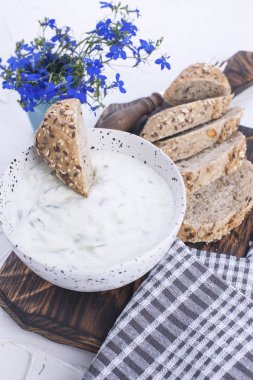 Salatalık ile yoğurt. Salatalık ile ünlü Yunan taziki taze daldırma. taze ekmek, havlu ve beyaz arka plan. Kopya alanı.