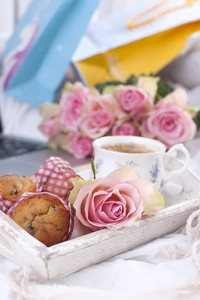 Białe łóżko, pakiety z prezenty, świeżą kawę, ciasta na śniadanie i bukiet róż. Dzień dobry Vintage zdjęcie. miejsce — Zdjęcie stockowe