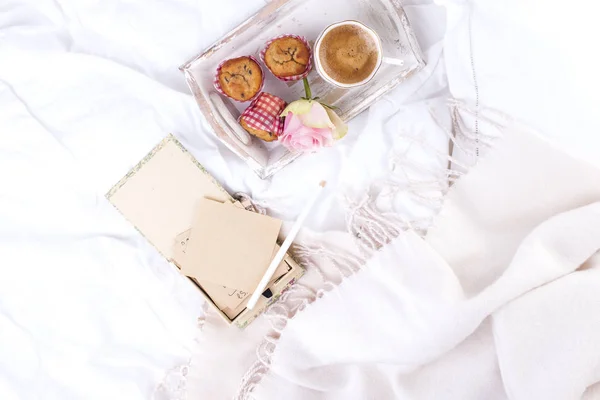 Weißes Bett, frischer Kaffee, Frühstückskuchen und ein Strauß rosa Rosen. Guten Morgen Vintage Foto. Kopierraum — Stockfoto