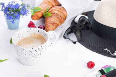 Bayan aksesuar, Bayan tatilde. Güneş gözlüğü ve şapka, kruvasan ve kahve kahvaltı için. Tatil ve bilet için belgeler. Beyaz arka plan. Kopya alanı