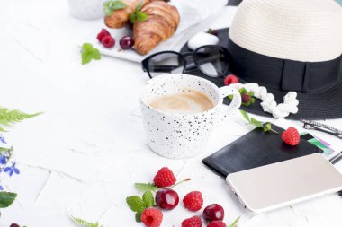 Bayan aksesuar, Bayan tatilde. Güneş gözlüğü ve şapka, kruvasan ve kahve kahvaltı için. Beyaz arka plan. Uzay kopyalayın. Düz yatıyordu