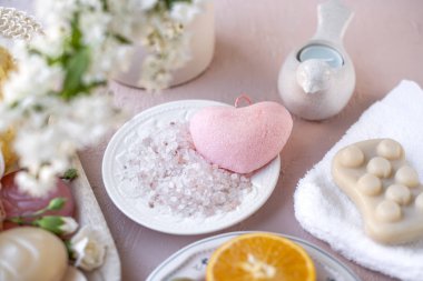 Spa aksesuarları ve çiçekler. pembe bir arka plan. Kopya alanı
