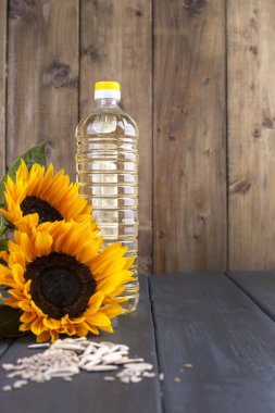 Şişe, bir buket ayçiçeği, terned bir arka plan ve dağınık tohum petrol dodsolnechnoe. Doğal ürün, rustik tarzı. Kopya alanı