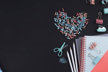 Birçok çok renkli ataç ve kağıt üzerinde siyah bir arka plan. Office kavramı. Okul için hedefler. Kopya alanı