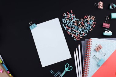 Birçok çok renkli ataç ve kağıt üzerinde siyah bir arka plan. Office kavramı. Okul için hedefler. Kopya alanı