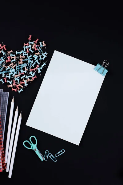 Viele bunte Büroklammern und Papier auf schwarzem Hintergrund. Bürokonzept. Fächer für die Schule. Kopierraum — Stockfoto