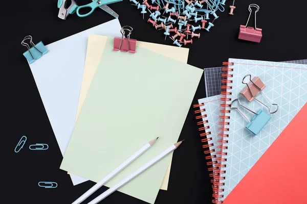 Birçok çok renkli ataç ve kağıt üzerinde siyah bir arka plan. Office kavramı. Okul için hedefler. Kopya alanı