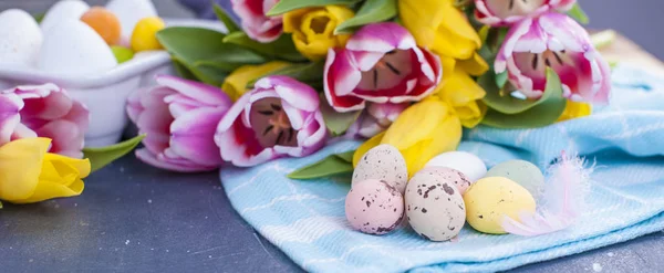 A bouquet of fresh spring tulips of pink and yellow color. Buds. Eggs for Easter are different colors. Bouquet as a gift, — Stock Photo, Image