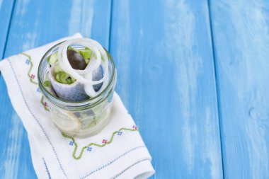 Geleneksel Hollanda limon ve bir kavanoz içinde soğan ile ringa balığı Marine. Mavi bir arka plan üzerinde deniz ürünleri. Kopya alanı