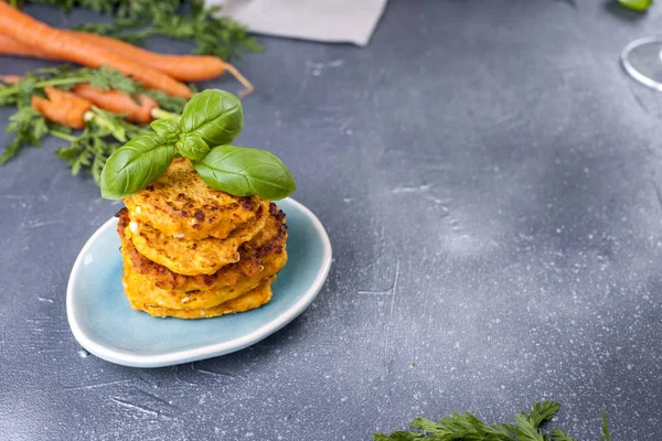 Frittelle da carota e basilico, cibo sano da verdure. Fondo grigio, verdure brillanti. Copia spazio — Foto Stock