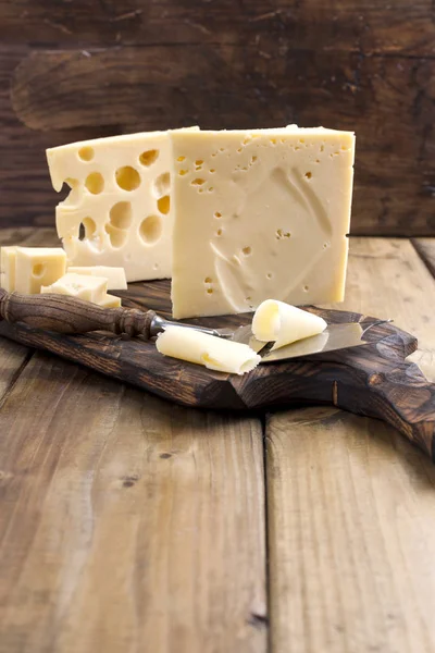 Peynir ile büyük ve küçük delikler. Ahşap tahta ve bıçak. Geleneksel Hollanda peynir. Kopya alanı. — Stok fotoğraf