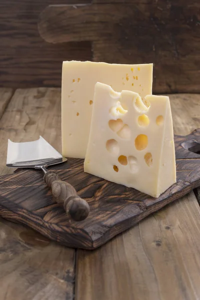 Geleneksel Hollanda peynir delikli bir vintage ahşap tahta, ahşap arka plan ve peynir bıçağı. Süt. Kopya alanı — Stok fotoğraf