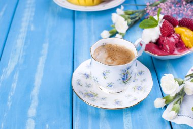 Mavi bir arka plan üzerinde farklı renkteki dondurma. Ahududu ve mango. Dekor çiçek ve sabah kahve. Metin için boş alan