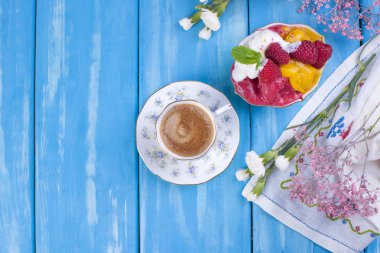 Mavi bir arka plan üzerinde farklı renkteki dondurma. Ahududu ve mango. Dekor çiçek ve sabah kahve. Metin için özgür yer. Yukarıdan görüntülemek