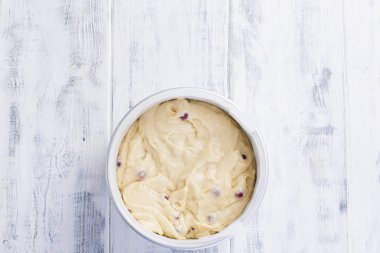 Kırmızı meyveler için ev yapımı pasta hamur içinde. Çelik bir kase içinde. Beyaz ahşap arka plan ve metin için boş alan.