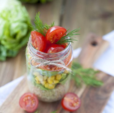 Katmanları bir kutu içinde taze sebze salatası. Sağlıklı gıda. Pencerenin yanında masada evde öğle yemeği. Metin veya bir kartpostal için boş alan
