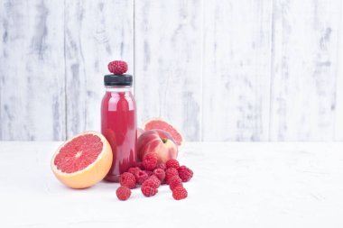 Taze ahududu, şeftali, greyfurt ve bir plastik şişe suyu. Detoks. Beyaz arka plan. Kopya alanı