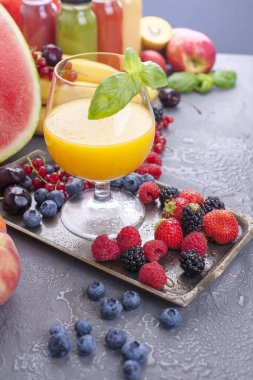 Farklı meyveler ve meyve üzerinde gri bir arka plan, taze sıkılmış meyve suyu. Vitamin ve detoks gıda. Kopya alanı
