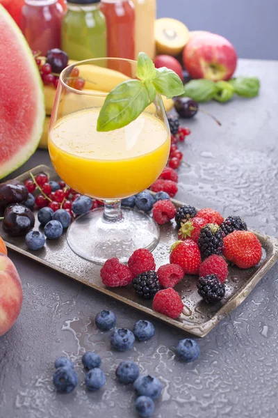 Farklı meyveler ve meyve üzerinde gri bir arka plan, taze sıkılmış meyve suyu. Vitamin ve detoks gıda. Kopya alanı
