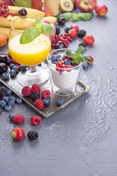 Farklı meyveler ve meyve bir gri arka plan, taze meyve, yoğurt ve kahvaltı için çilek suyu. Vitamin ve detoks gıda. Kopya alanı