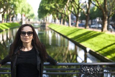 Kız kentin yeşil ağaçlar ırmak Caddesi üzerinde poz. Turizm ve Travel.Copy alanı