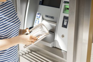 Bir kadın sokakta bir Atm de kredi kartı kullanır. Para ile çalışma. Ödeme. Kopya alanı